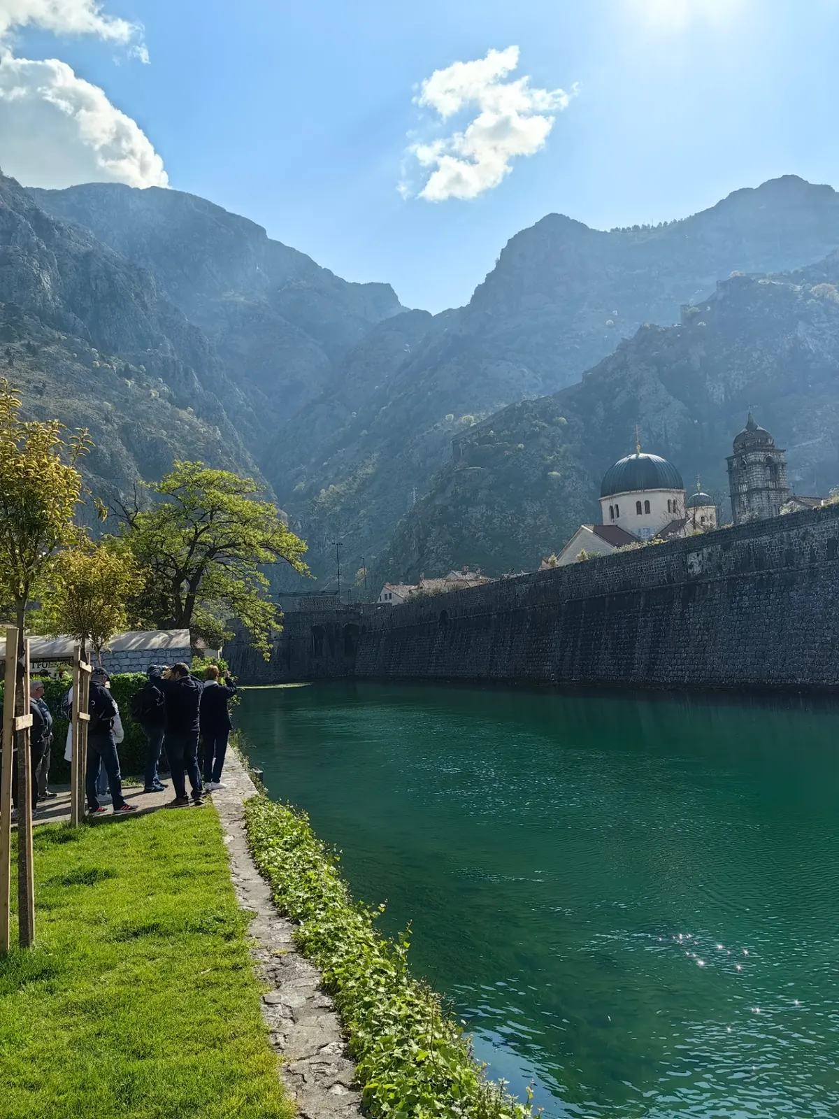 Kotor old town walls beside emerald water under mountain peaks